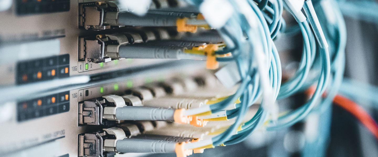 Viele petrolfarbene Kabel, die an einen Server angeschlossen sind.
