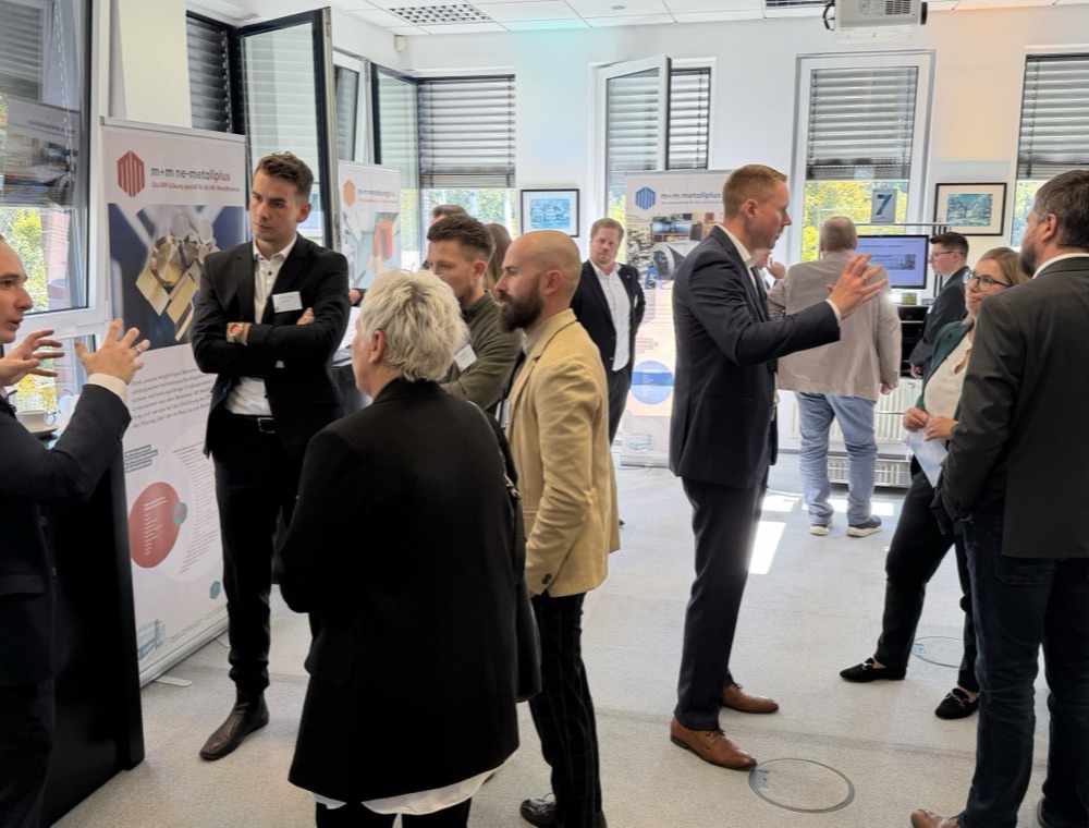 Besucher im Gespräch an einem Messestand der m+m Zukunftstage 2026 bei markmann + müller in Herdecke.